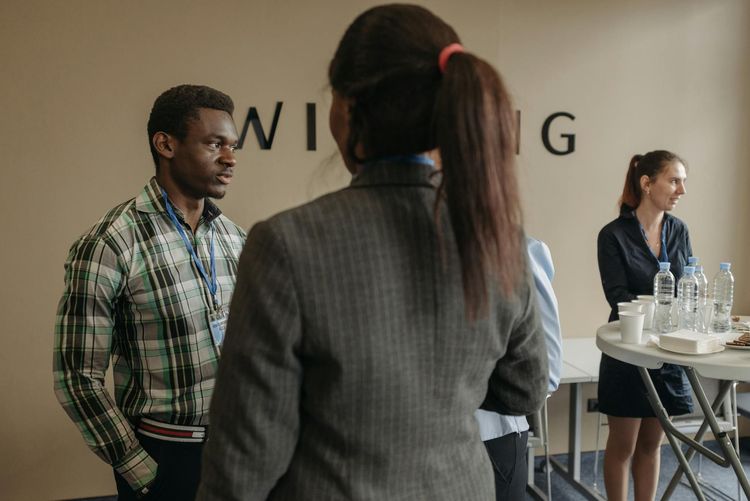 A diverse group of professionals networking at an indoor business seminar.