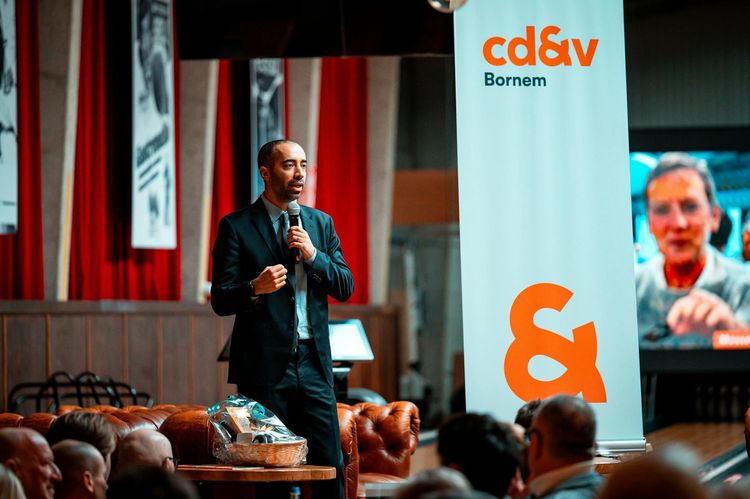 Male speaker presenting at a corporate event. Audiences are engaged indoors.