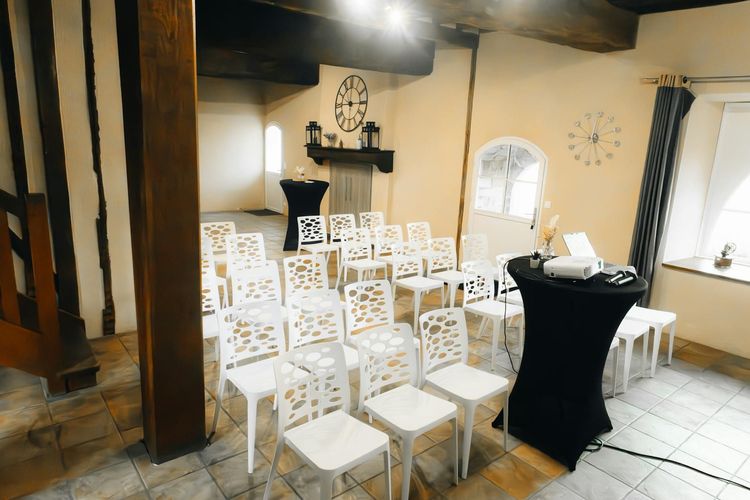 Spacious conference room with stylish white chairs and modern decor, ideal for seminars.