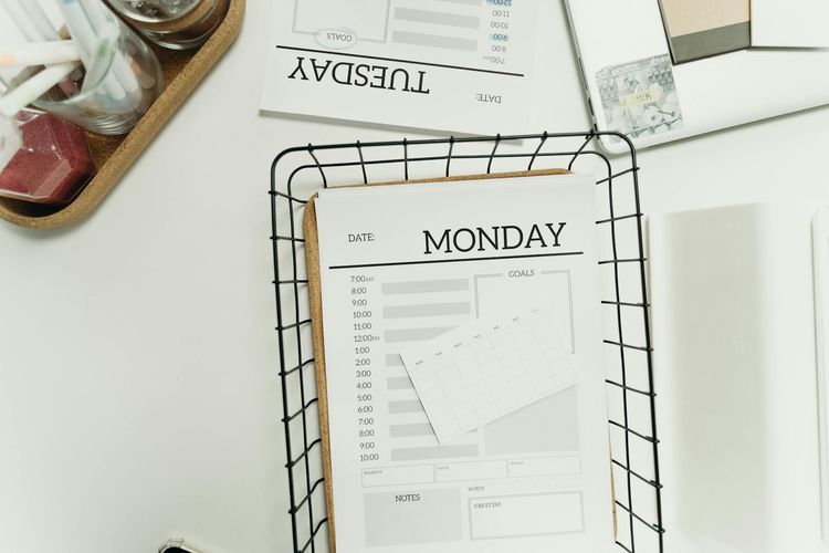 Top view of a modern, minimalist weekly planner setup showing Monday and Tuesday pages.