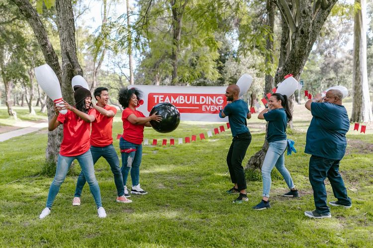 Dynamic outdoor team building activity with diverse group playing in the park.