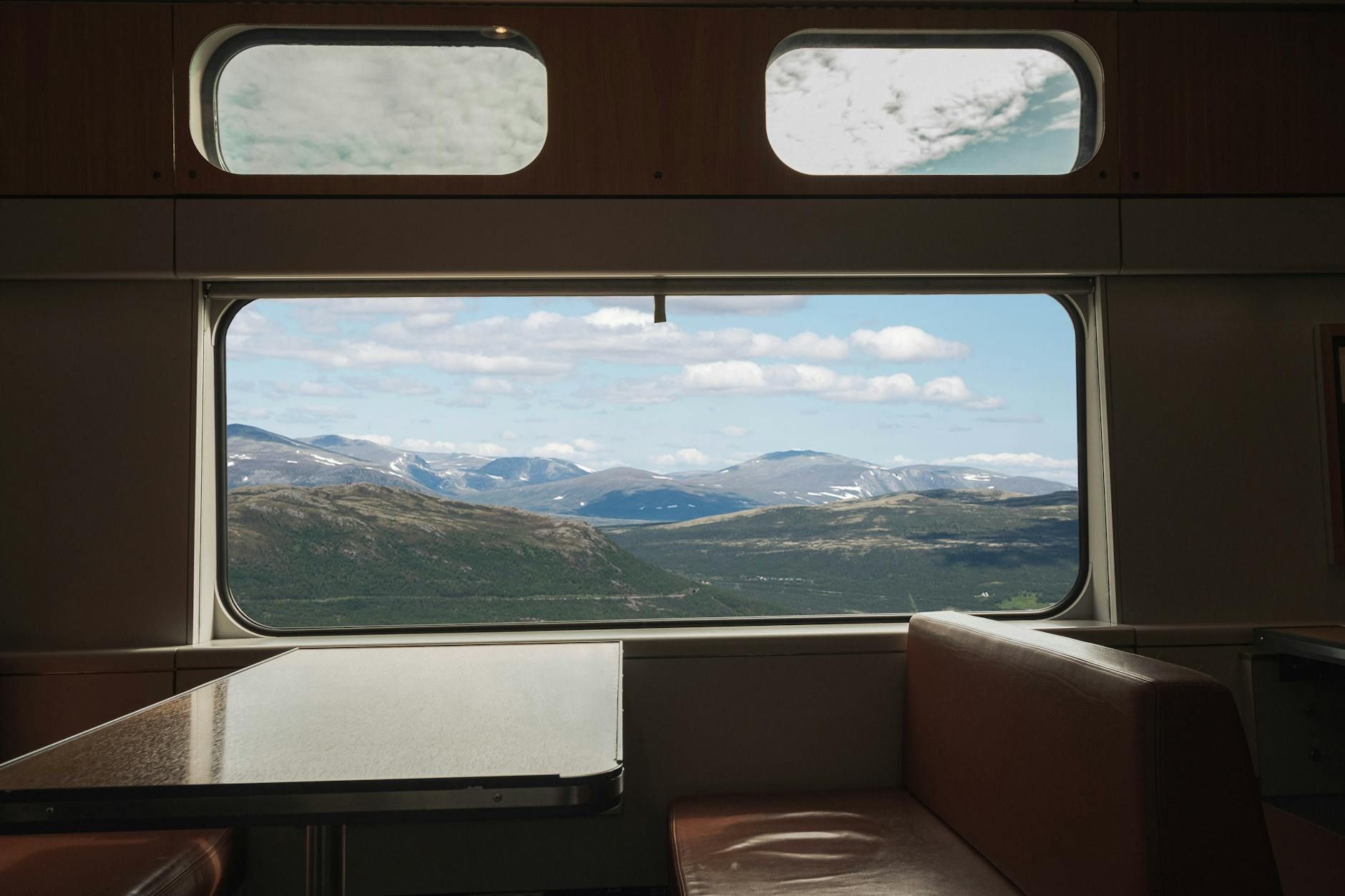 View from a train window overlooking vast mountainous landscape, capturing travel serenity. View from a train window overlooking vast mountainous landscape, capturing travel serenity.