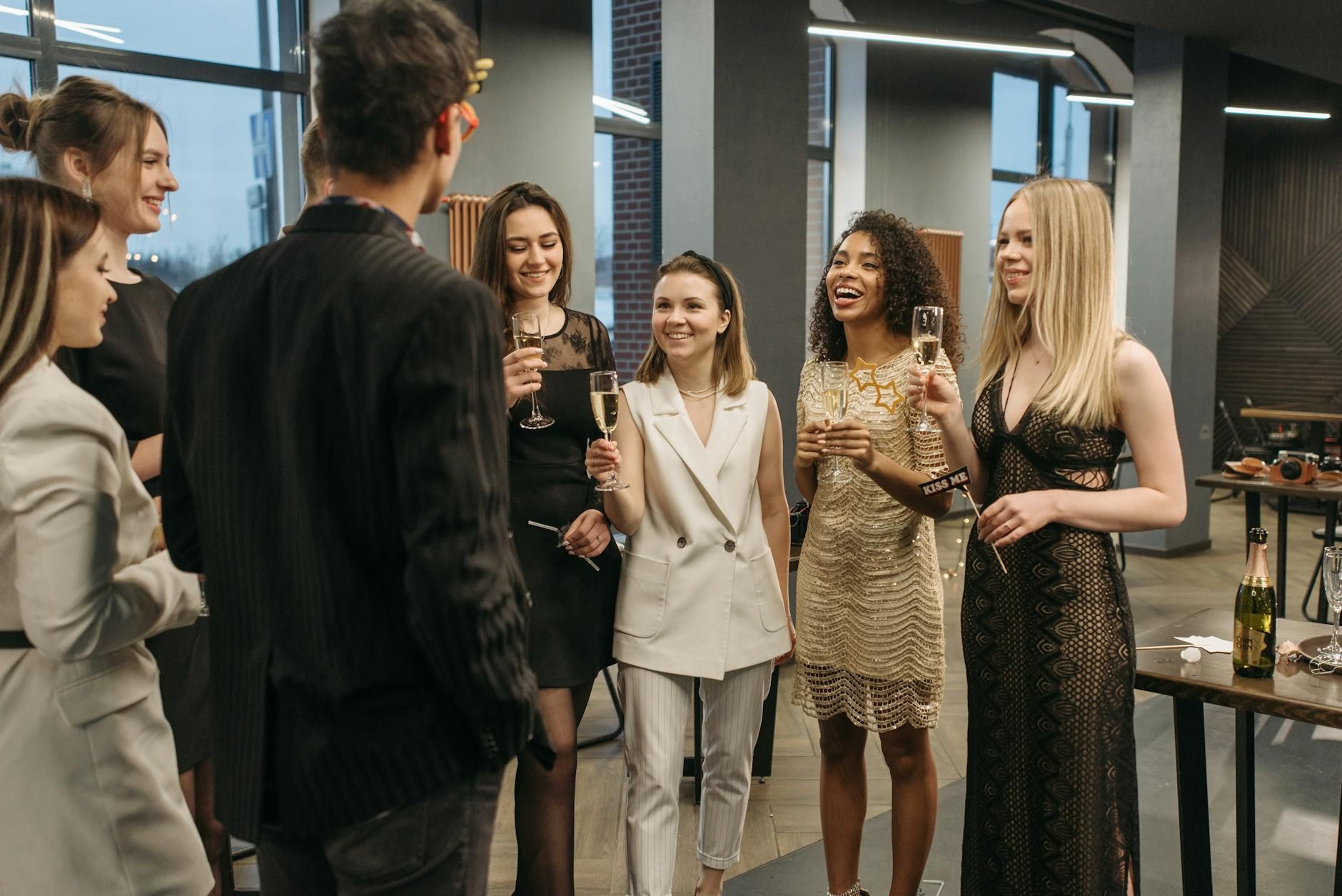 A diverse group of colleagues celebrating with drinks indoors, showcasing diversity and camaraderie.