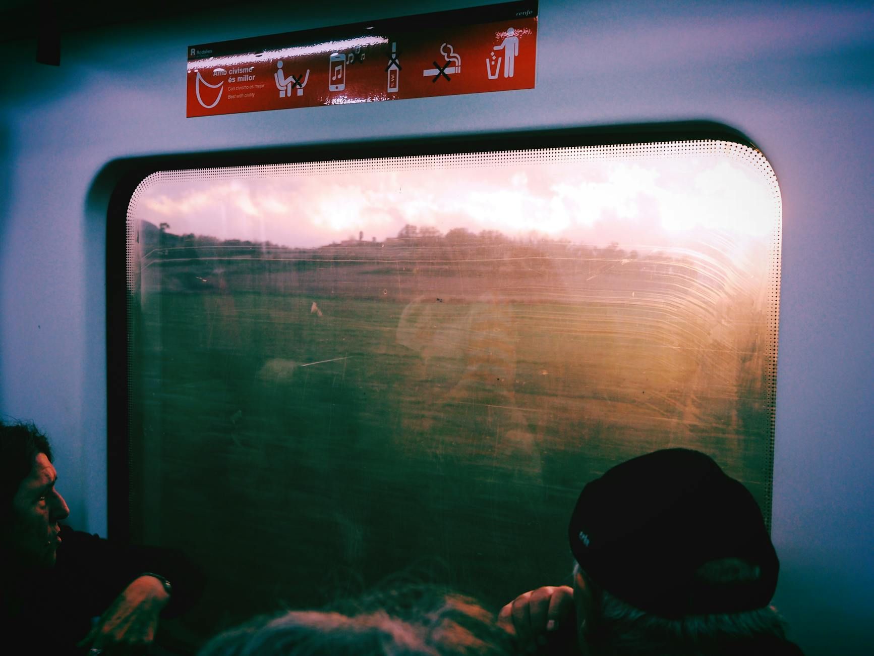 Passenger view from a train window in Barcelona, capturing scenic landscapes at sunset. Passenger view from a train window in Barcelona, capturing scenic landscapes at sunset.