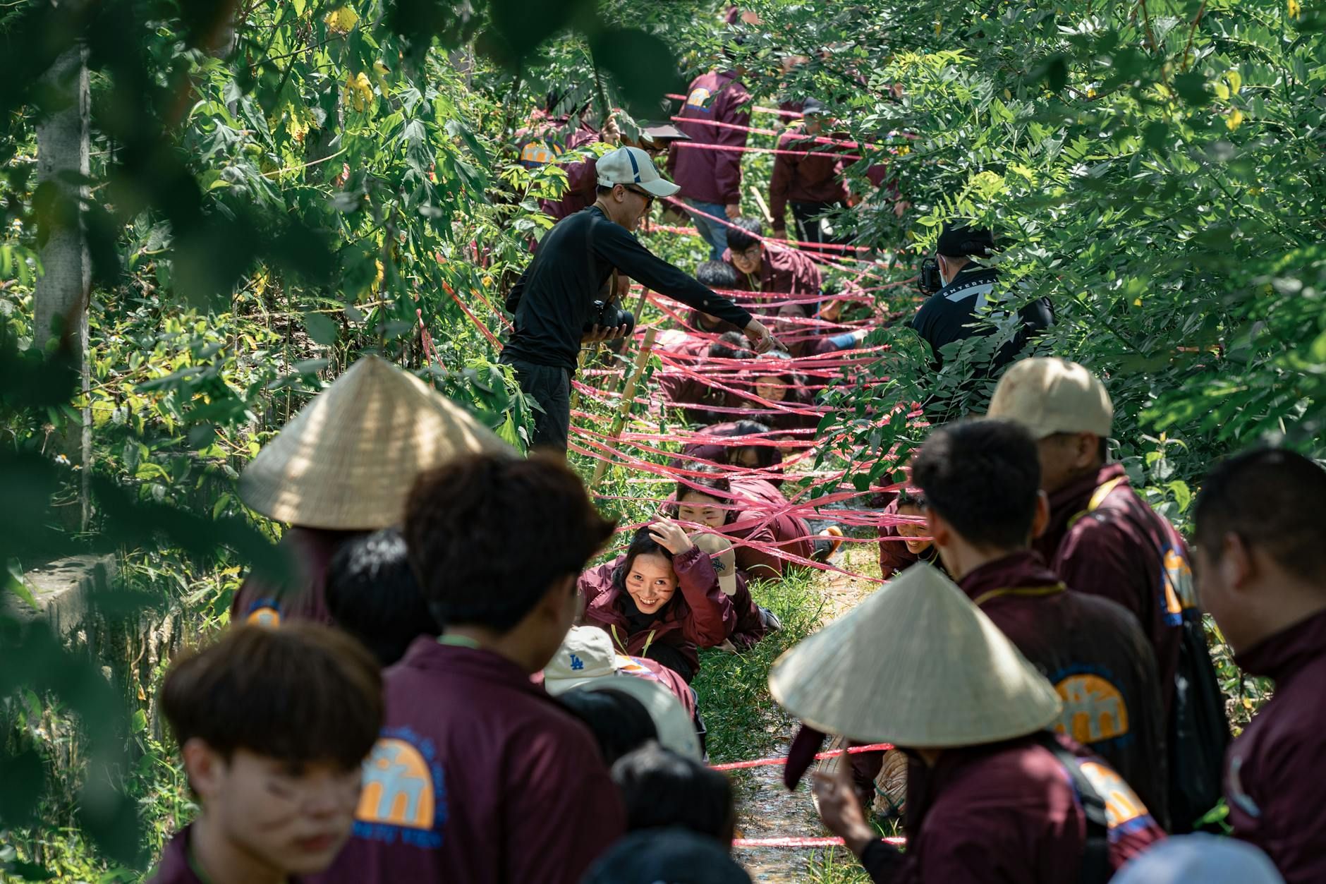 Participants navigate obstacle course in lush forest during adventure event.