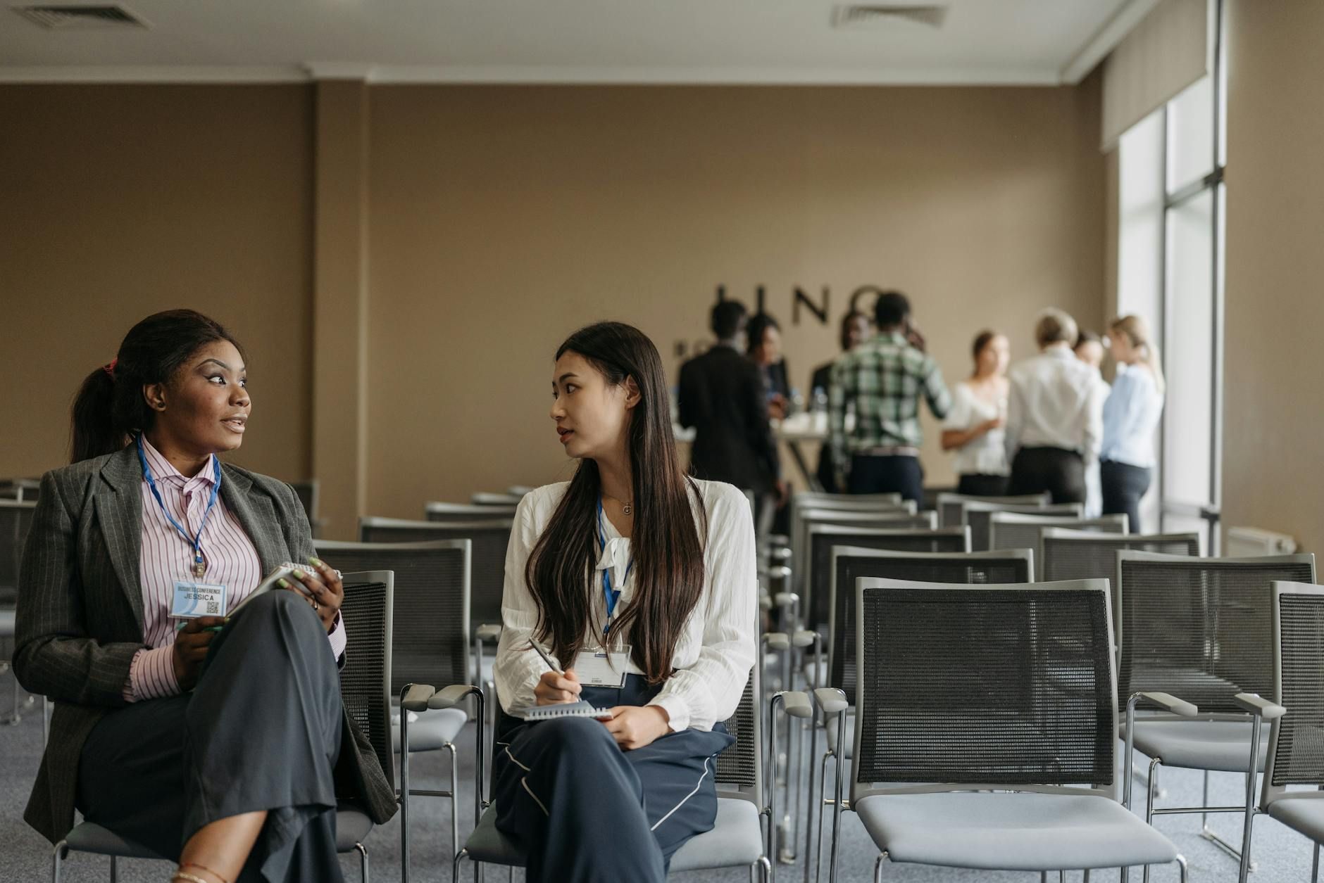 Two businesswomen in conversation during a break at a conference. Two businesswomen in conversation during a break at a conference.
