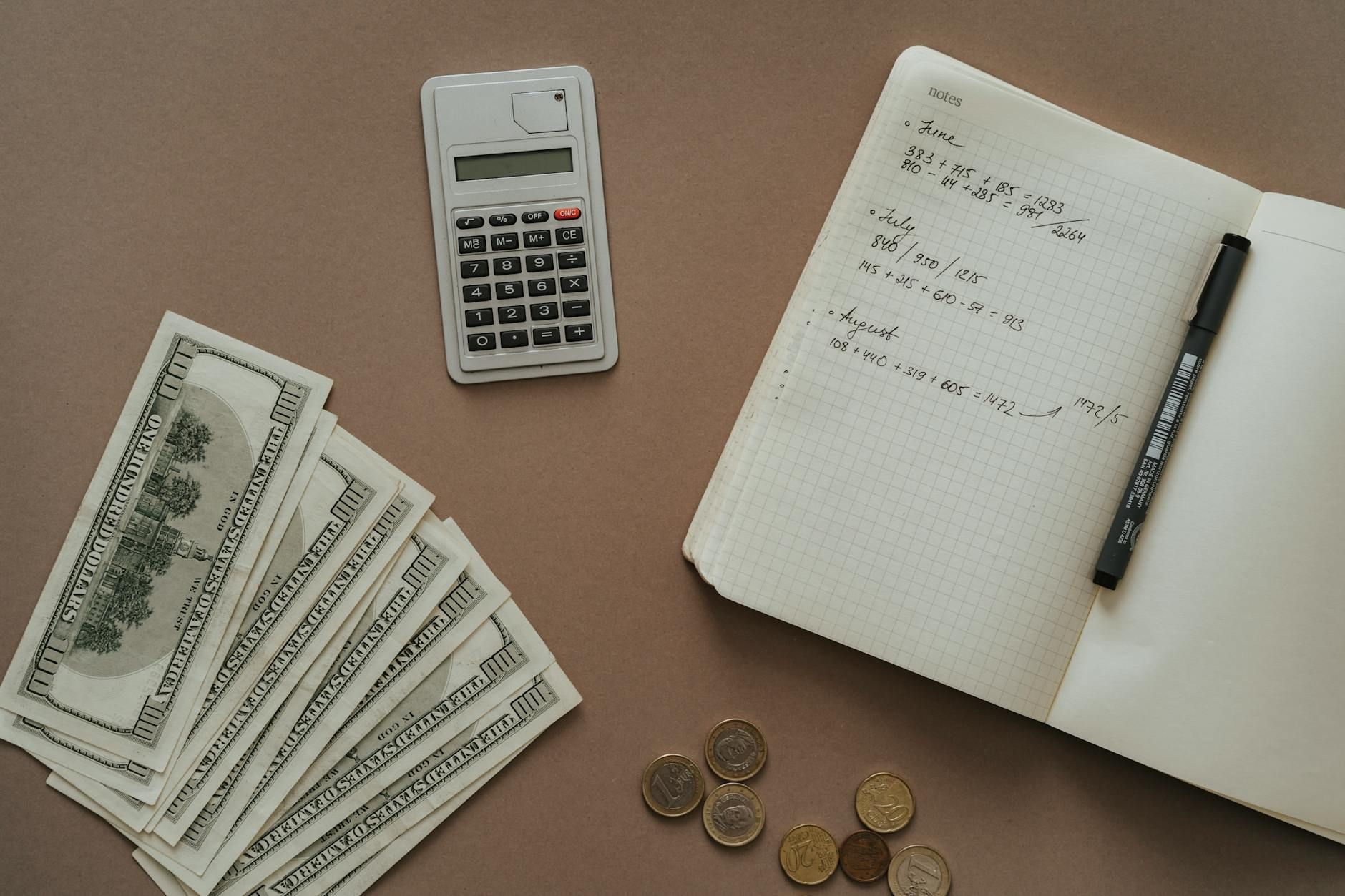 Flat lay with calculator, notebook, and US dollars ideal for financial concepts. Flat lay with calculator, notebook, and US dollars ideal for financial concepts.