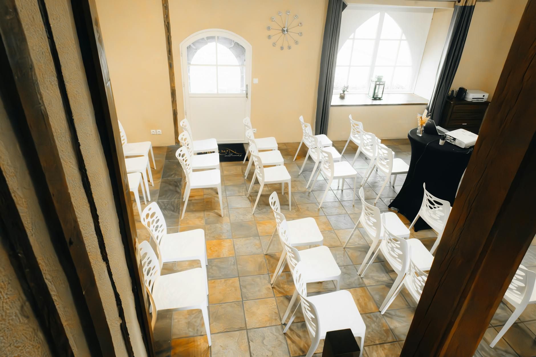 Bright meeting room setup with white chairs and large windows for natural light.