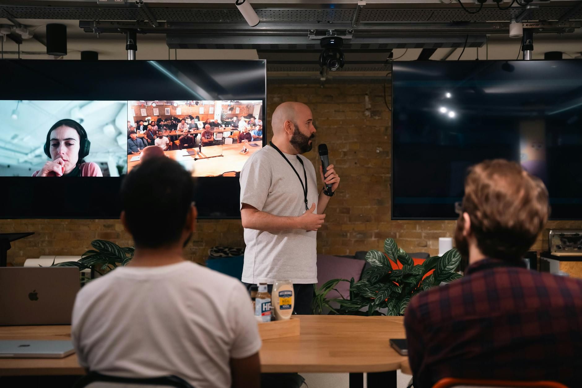 A business presentation featuring a speaker and interactive video call in an office setting. A business presentation featuring a speaker and interactive video call in an office setting.