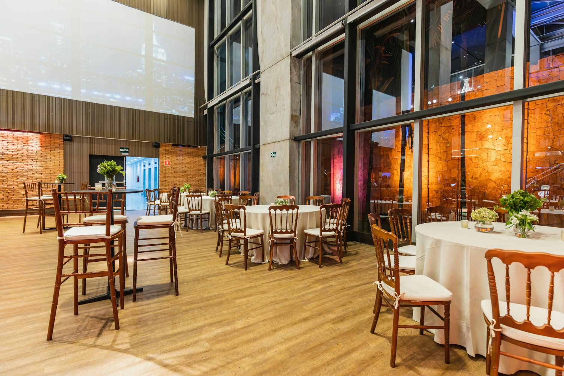 Espacio interior elegante con mesas redondas y sillas, perfecto para celebraciones.