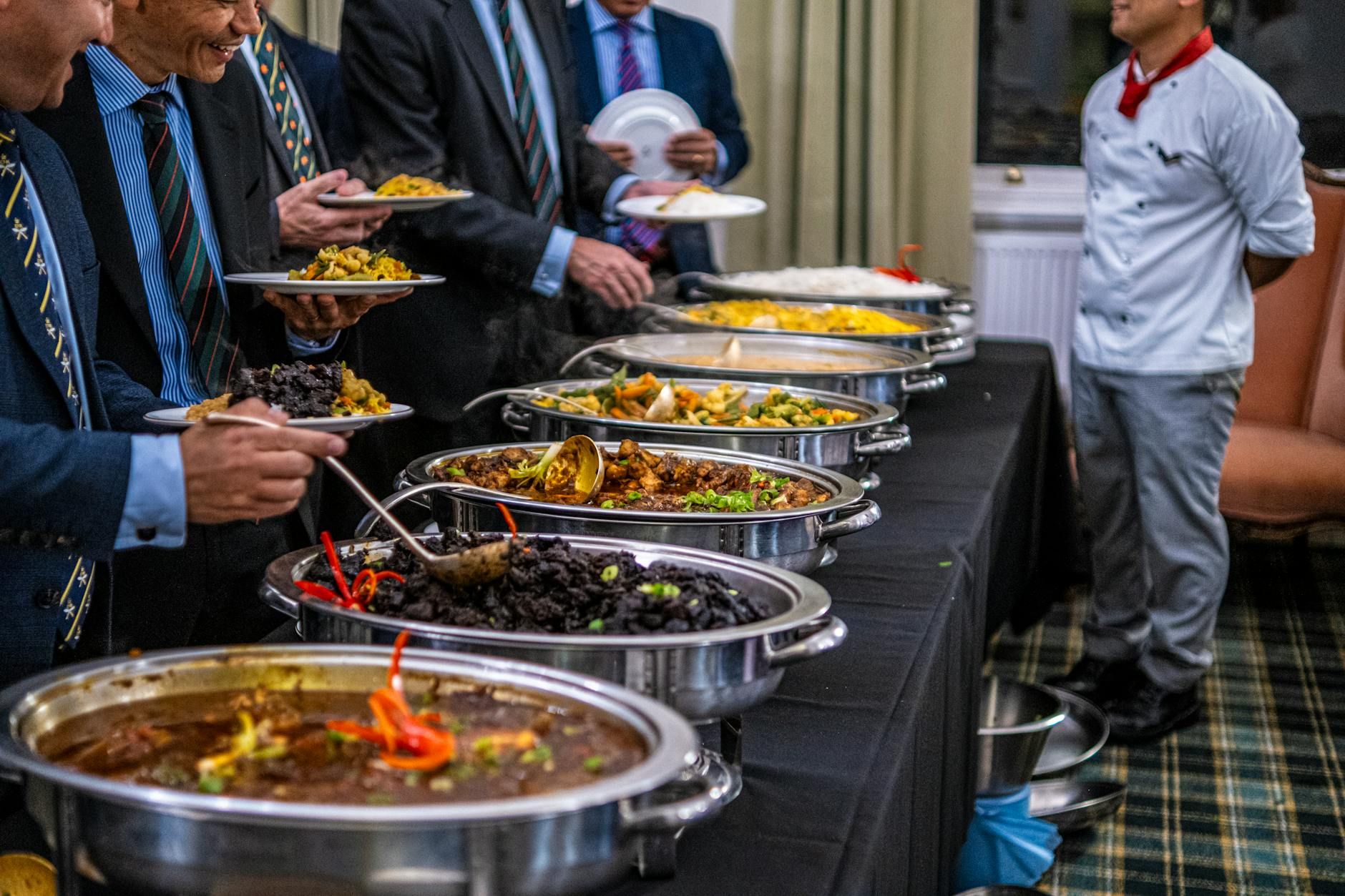 Profesionales de negocios con traje disfrutan de un variado buffet en un evento formal. Profesionales de negocios con traje disfrutan de un variado buffet en un evento formal.
