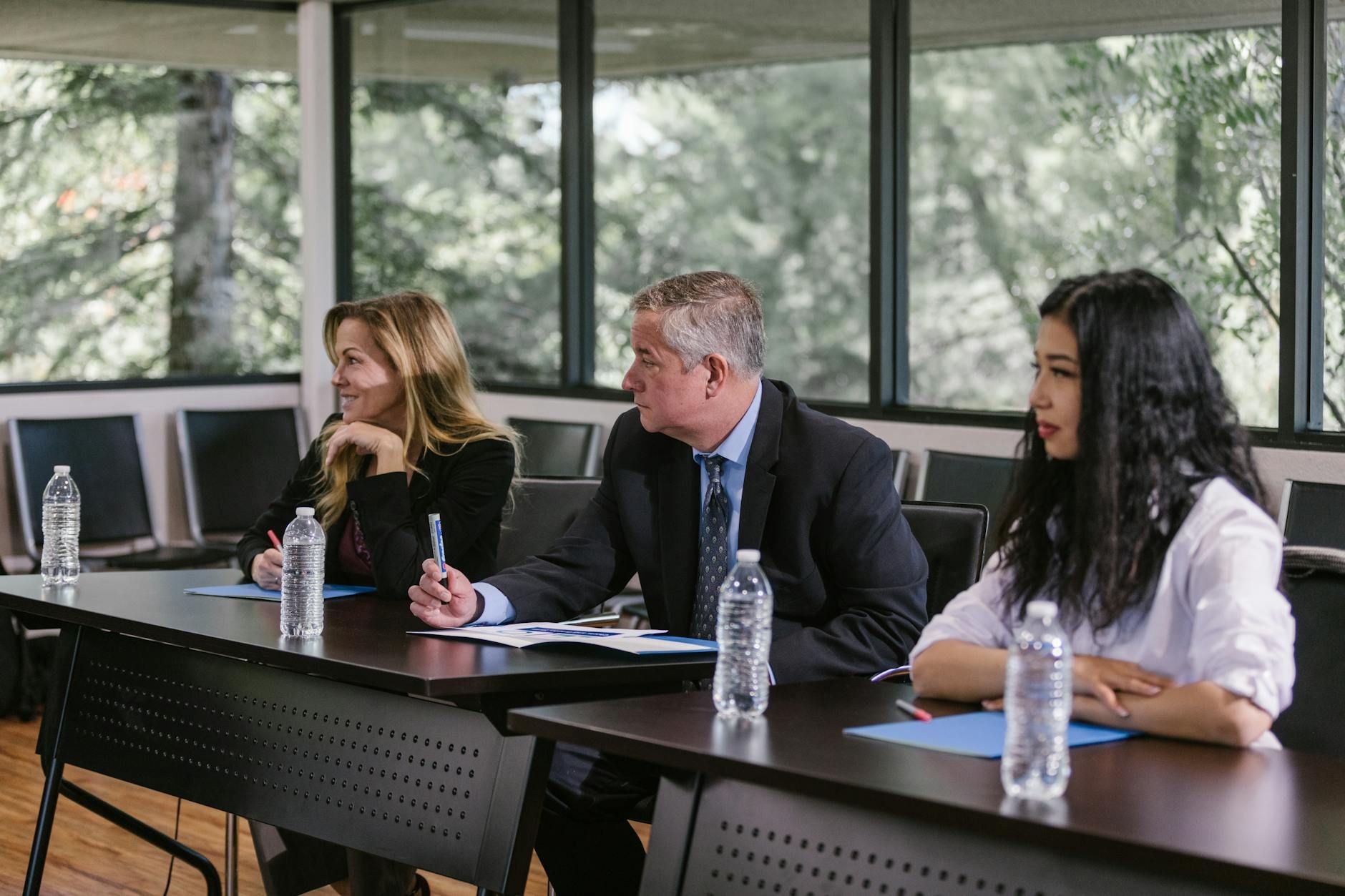 Diverse professionals engaged in a business meeting in a modern conference room. Diverse professionals engaged in a business meeting in a modern conference room.